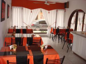 a restaurant with tables and chairs in a room at Hotel Aldea Marina in Villa Gesell