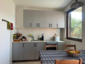 a kitchen with white cabinets and a table with a bowl of fruit at Pier Apartments in Krašići