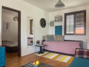 a bedroom with a bed and a clock on the wall at Pier Apartments in Krašići