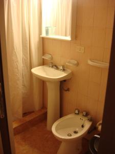 a small bathroom with a sink and a toilet at Hotel Aldea Marina in Villa Gesell