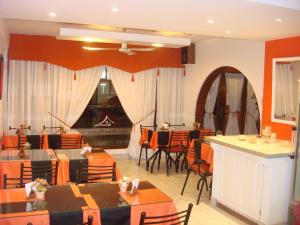 Un restaurante con mesas y sillas y chimenea. en Hotel Aldea Marina, en Villa Gesell 43 fotos más