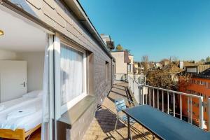 苏黎世Fantastic Penthouse near Lake - Mainau 14的阳台配有床、桌子和窗户。
