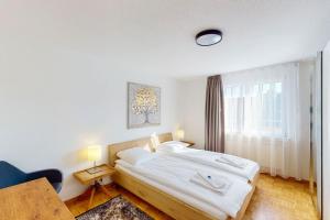 苏黎世Fantastic Penthouse near Lake - Mainau 14的卧室里有一张铺着白色床单的床和一扇窗户