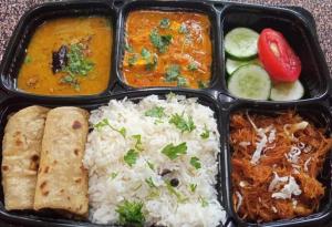 a lunch box with rice and different types of food at Five BHK Abode in Golf City Lucknow in Nalmatha