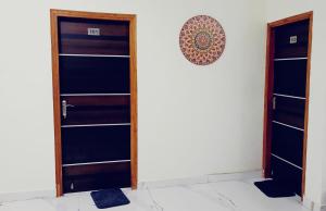 a room with two wooden doors and a wall at Five BHK Abode in Golf City Lucknow in Nalmatha