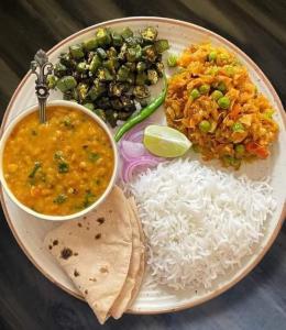 a plate of food with rice and different types of food at Five BHK Abode in Golf City Lucknow in Nalmatha +20 photos
