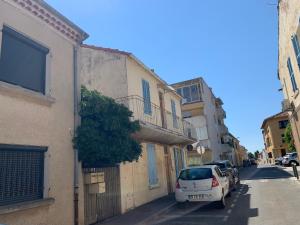 a white car parked next to a building on a street at T2 cœur de ville La Londe-Les-Maures in La Londe-les-Maures