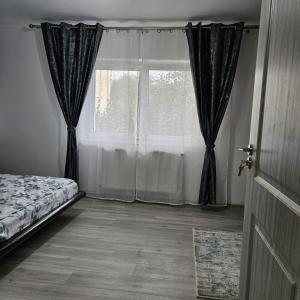 a bedroom with a bed and a large window at Garsoniera Delia in Braşov