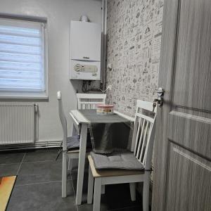 a kitchen with a table and two chairs and a door at Garsoniera Delia in Braşov