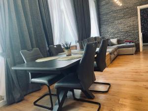 a dining room with a table and chairs and a couch at Apartamentai senamiestyje in Šilutė