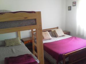 a bedroom with two bunk beds with purple sheets at La Casa de Ramatis Posada in Valle Hermoso +49 photos