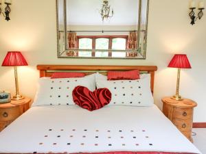 a bedroom with a bed with two lamps and a mirror at Derwen Villa in Mydroilin