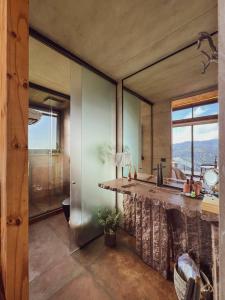 a kitchen with a large counter and a large window at Cabanas Terrunyo - Cabana Bela in Urubici