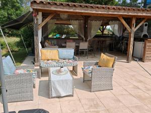 a patio with wicker chairs and a gazebo at Mulberry Gite in Peyrat-de-Bellac