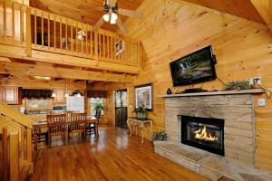 a living room with a fireplace and a dining room at Mountain Serenity in Gatlinburg