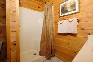 a bathroom with a shower and a bath tub at Mountain Serenity in Gatlinburg +30 photos
