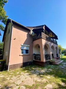 a house with a balcony on the side of it at Tieffapartmanház Zamardi in Zamárdi