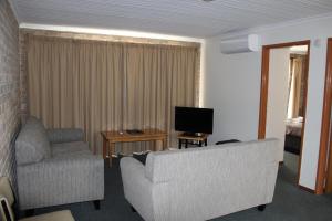 a living room with a couch and a television at Burnie Ocean View Motel and Caravan Park in Burnie