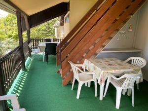 a porch with a table and chairs and a staircase at Tieffapartmanház Zamardi in Zamárdi