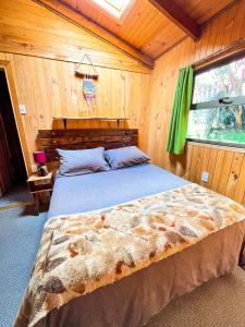 a bedroom with a bed in a wooden room at Patagonia Nativa in Cochamó