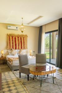 a bedroom with a bed and a chair and a table at RIMALIZ House in Amizmiz