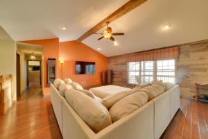 a large couch in a living room with orange walls at Peaceful Big Sandy Home with Deck on Kentucky Lake! in Big Sandy