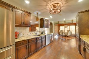 a large kitchen with wooden cabinets and a table at Peaceful Big Sandy Home with Deck on Kentucky Lake! in Big Sandy