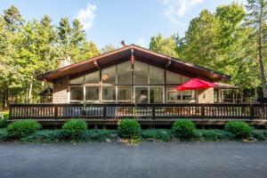 托伯莫里Evergreen Escape - Tobermory Chalet & Sauna的一座带门廊和红伞的房子