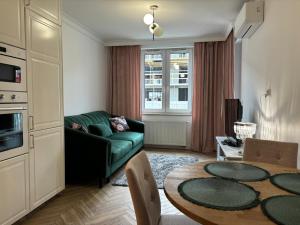 a living room with a green couch and a table at Apartamenty w centrum Białegostoku z parkingiem w garażu podziemnym in Białystok +42 photos