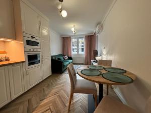 a living room with a table and a kitchen at Apartamenty w centrum Białegostoku z parkingiem w garażu podziemnym in Białystok