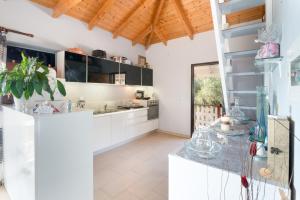 a kitchen with white cabinets and a wooden ceiling at Anthi's House in Vlachopoulátika