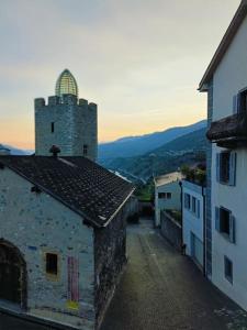 an old building with a clock tower on a street at Casa Jenini - Wohnung im Patrizierhaus neben Schloss Leuk in Leuk