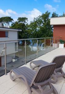 里沃Apartament Zachodni Rewal的两把椅子坐在大楼的阳台上