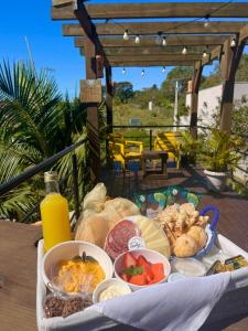 a tray of food sitting on top of a table at Capim Limão Containers do Rosa in Praia do Rosa