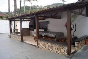 a wooden pavilion with a table on a patio at Casa super confortável para você e sua família, próximo a praia in Guarujá