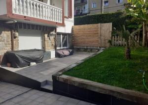 a backyard with a lawn and a building with a garage at Piso en San Sebastián in Pasajes Ancho