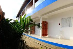 a house with blue and white walls and a plant at Pousada JMedina Maresias in Maresias +4 photos
