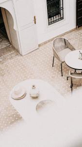 une chambre avec une table, une chaise, une table et des chaises dans l'établissement Riad KRÈME, à Marrakech