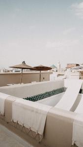 un bâtiment blanc avec des parapluies sur le toit dans l'établissement Riad KRÈME, à Marrakech