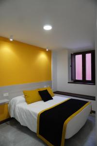 una camera da letto con un letto grande con una parete gialla di APARTAMENTO Sanin 2 a Lumbrales