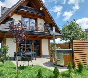 a house with a balcony and a yard at Domki Na Brzyzku in Zakopane