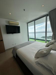 une chambre avec un grand lit avec une grande fenêtre dans l'établissement Playa Boquilla -Condo Hotel Sonnesta Cartagena- Vista hermosa a la Ciénaga piso Alto, à Carthagène des Indes