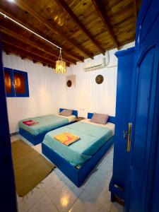 two beds in a room with a blue door at Blue Villa in Lighthouse in Dahab +24 photos