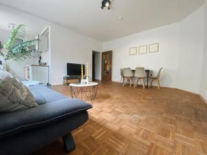 a living room with a couch and a wooden floor at LEON Sleep&Stay in Kassel