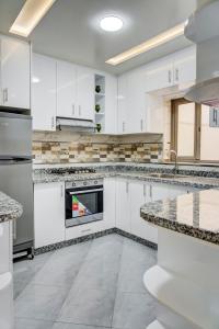 cocina grande con armarios y electrodomésticos blancos en jaws wave imsouane, en Imsouane