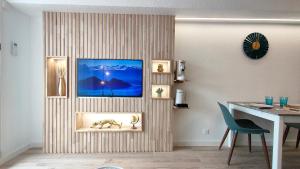 a living room with a table and a painting on a wall at Appartement cosy en centre-ville de Royan à 200m plage in Royan