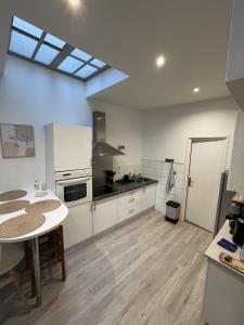 a kitchen with white cabinets and a table in it at Escapade marseillaise in Marseille