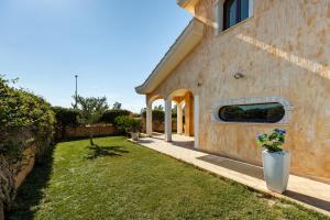 una casa di mattoni con un cortile con un cortile sidx sidx di Villa Margot-Garden & Whirpool -5 Min to the beach a Quartu SantʼElena