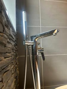 a shower in a bathroom with a shower head at Entire Seaside Home 6 Private BedRooms Sleeps 10,4 Minute Walk To Station in New Brighton +41 photos