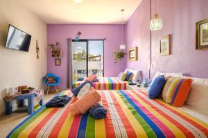 a bedroom with two beds with a colorful blanket at Casa Itzae La Antigua Dog Friendly in San Miguel de Allende